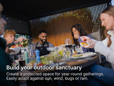 People enjoying a meal together at an outdoor table under a pergola with text overlay about building an outdoor sanctuary.