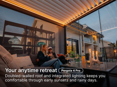 Two people sitting on a couch in a modern outdoor living pergola