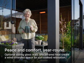 Woman standing on a patio in a pergola with sliding glass walls and plants