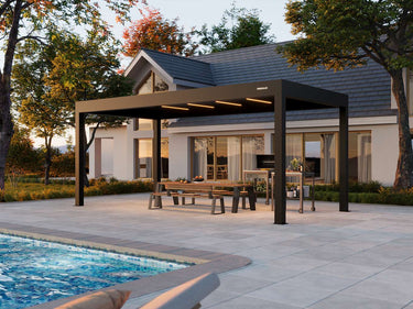 Patio with pergola, table, and chairs near a pool with a house in the background