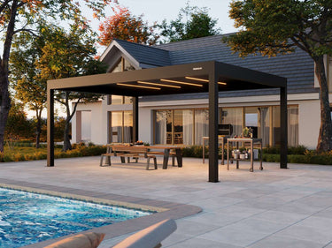 Patio with pergola, table, chairs, and pool area in front of a house.