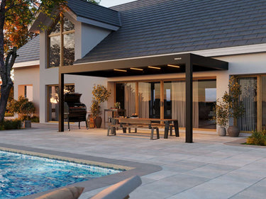 Modern patio cover with outdoor furniture by a poolside